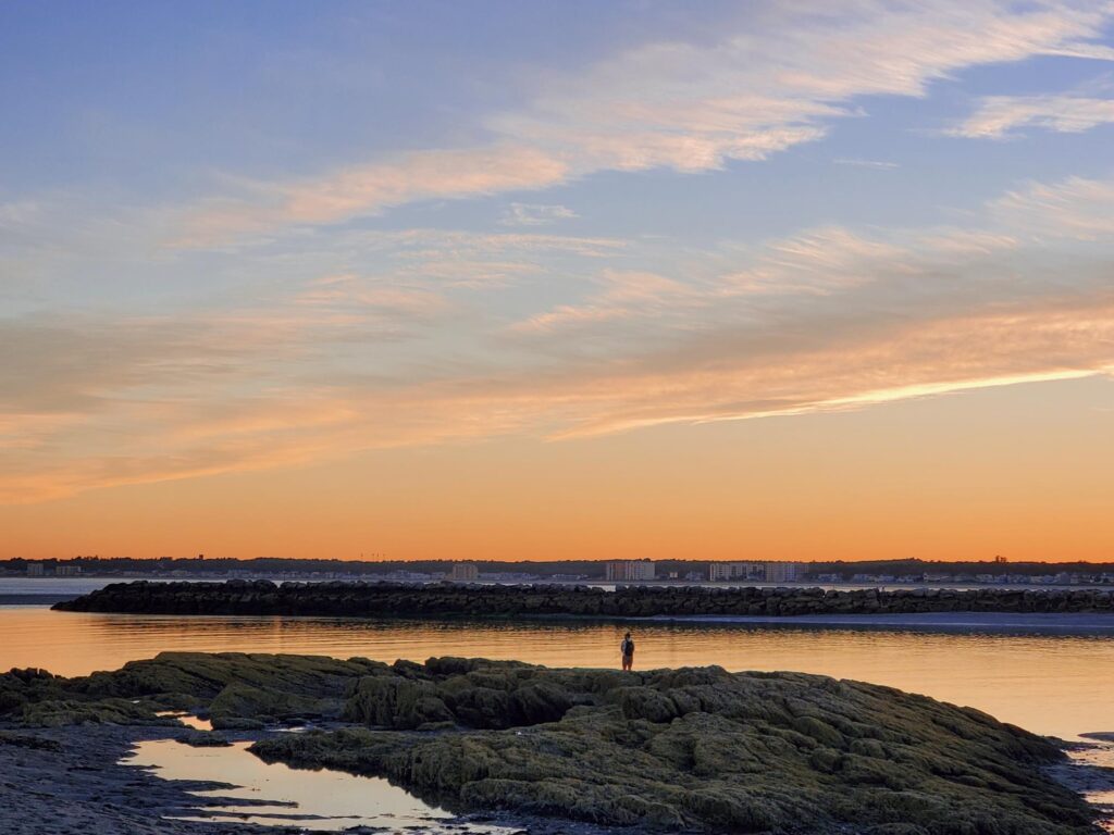 Orange and pink sunset over a calm tidal flat